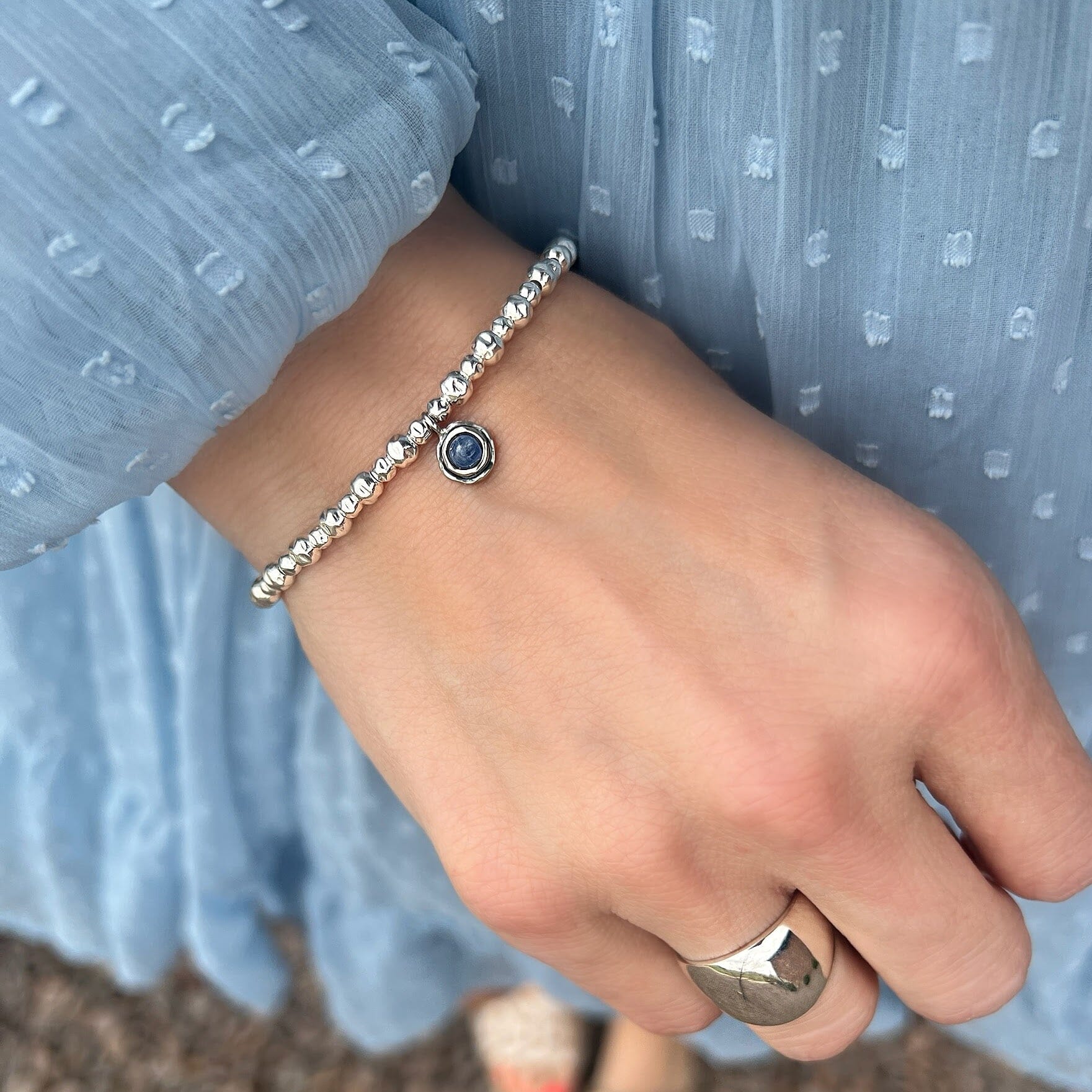 slightly hammered silver beaded bracelet featuring round blue kyanite