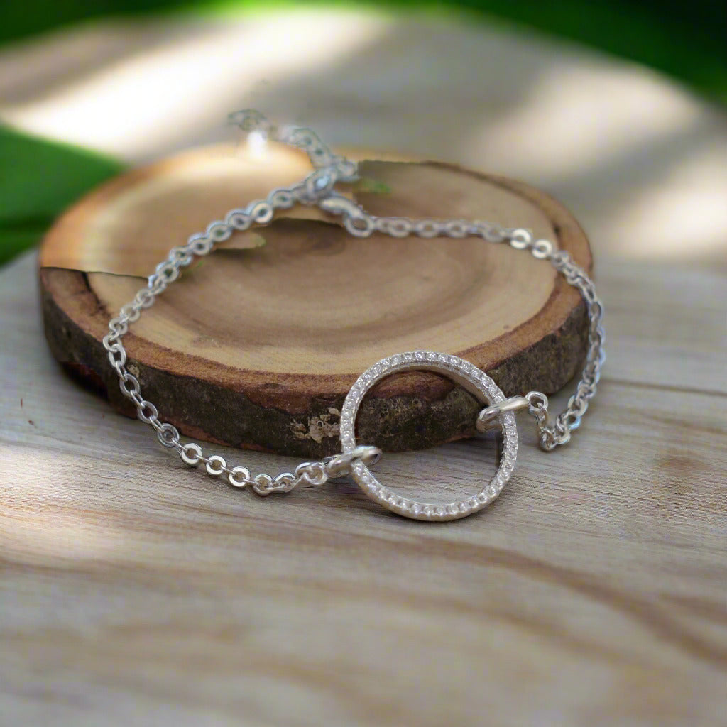 minimalist silver bracelet featuring a circular pendant with pave-set CZs