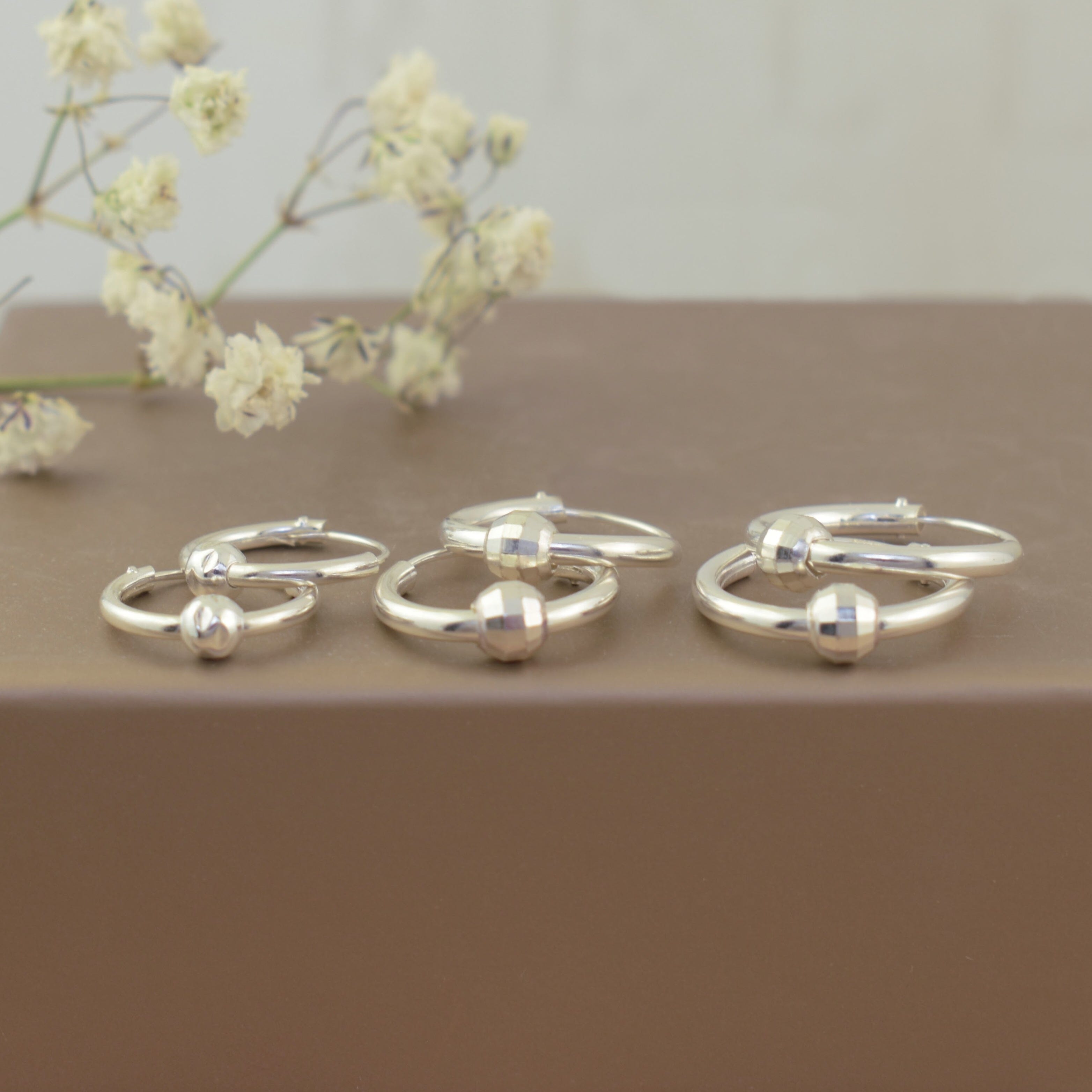 minimalist silver continuous hoops featuring a disco style sliding bead