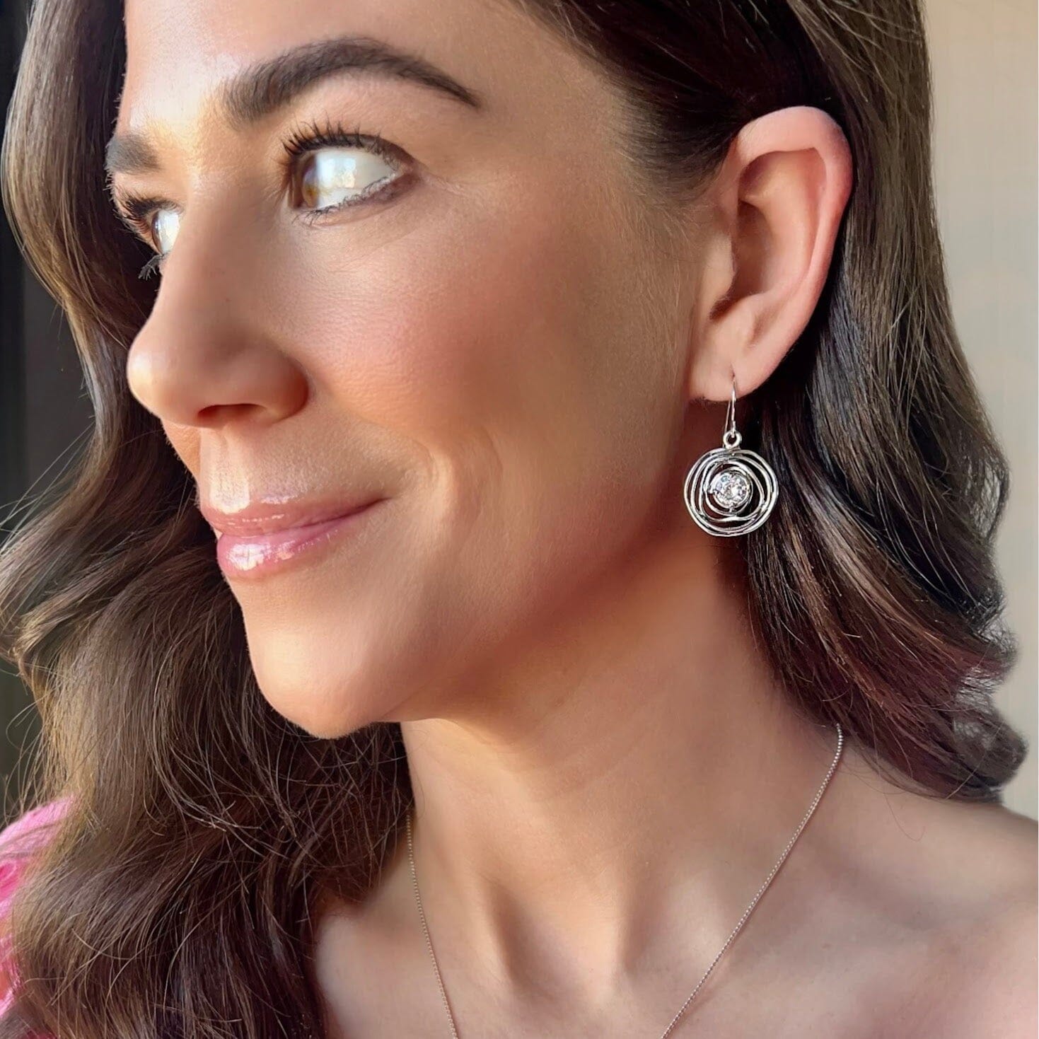 clear cubic zirconia prong-set in a round organically spun silver earring dangle