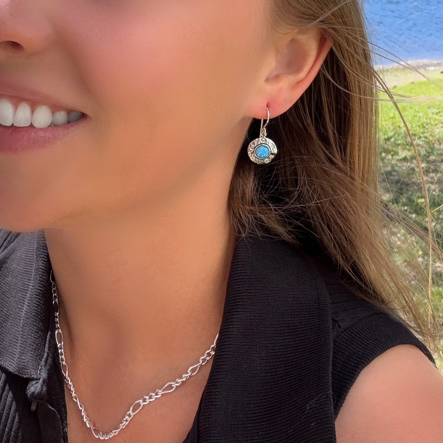 sterling silver round earring with a circle opal stone in the center.