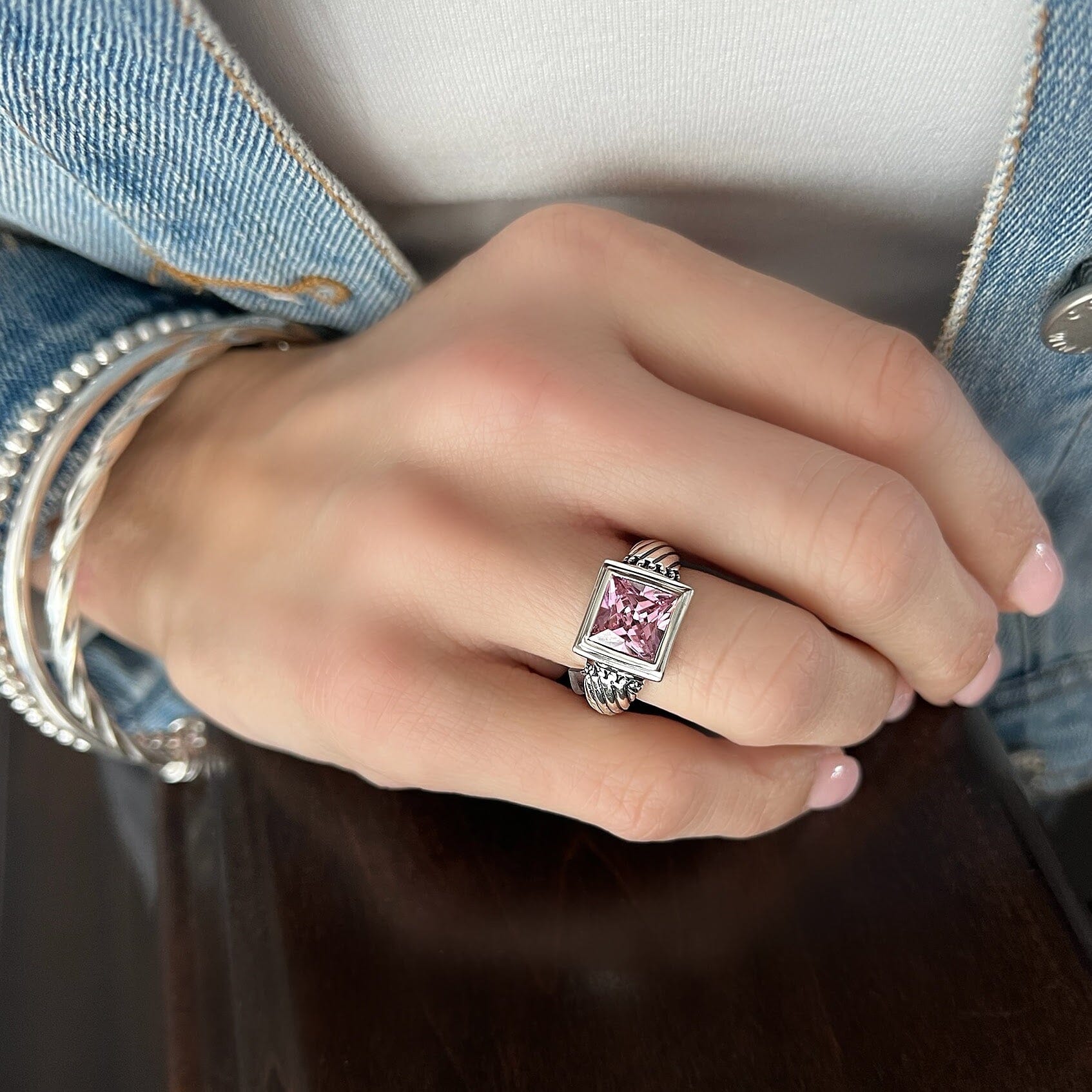 sterling silver ring with swirl engraved band and a square pink CZ stone
