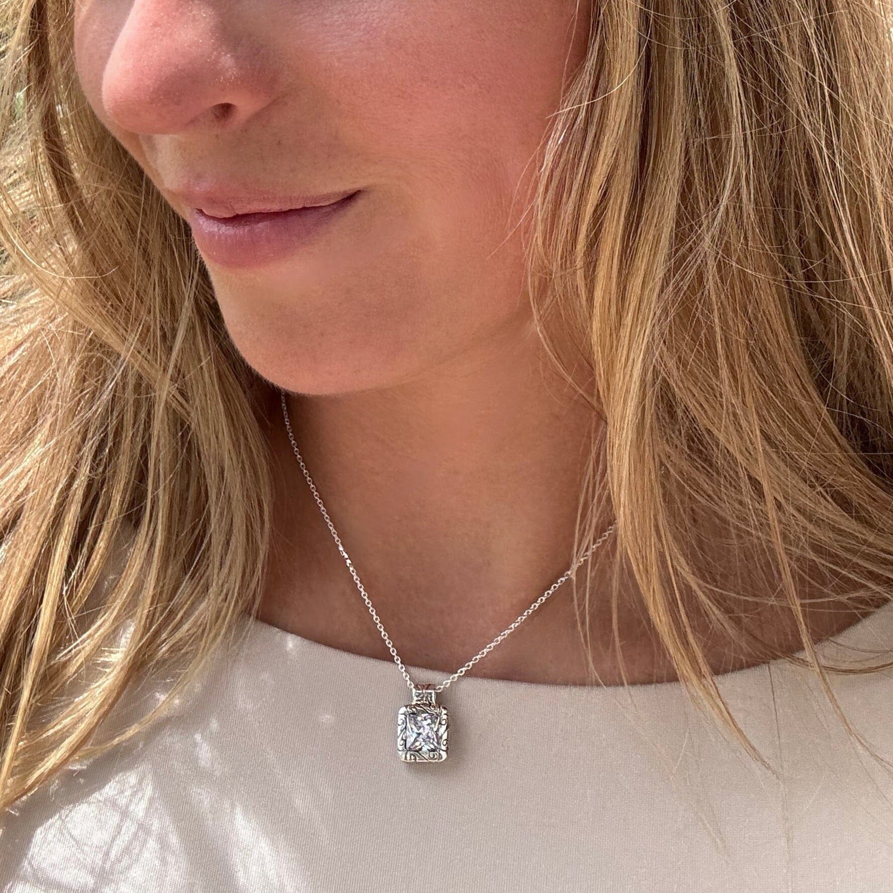 filigree design rectangular pendant featuring princess cut cubic zirconia on a silver rolo chain