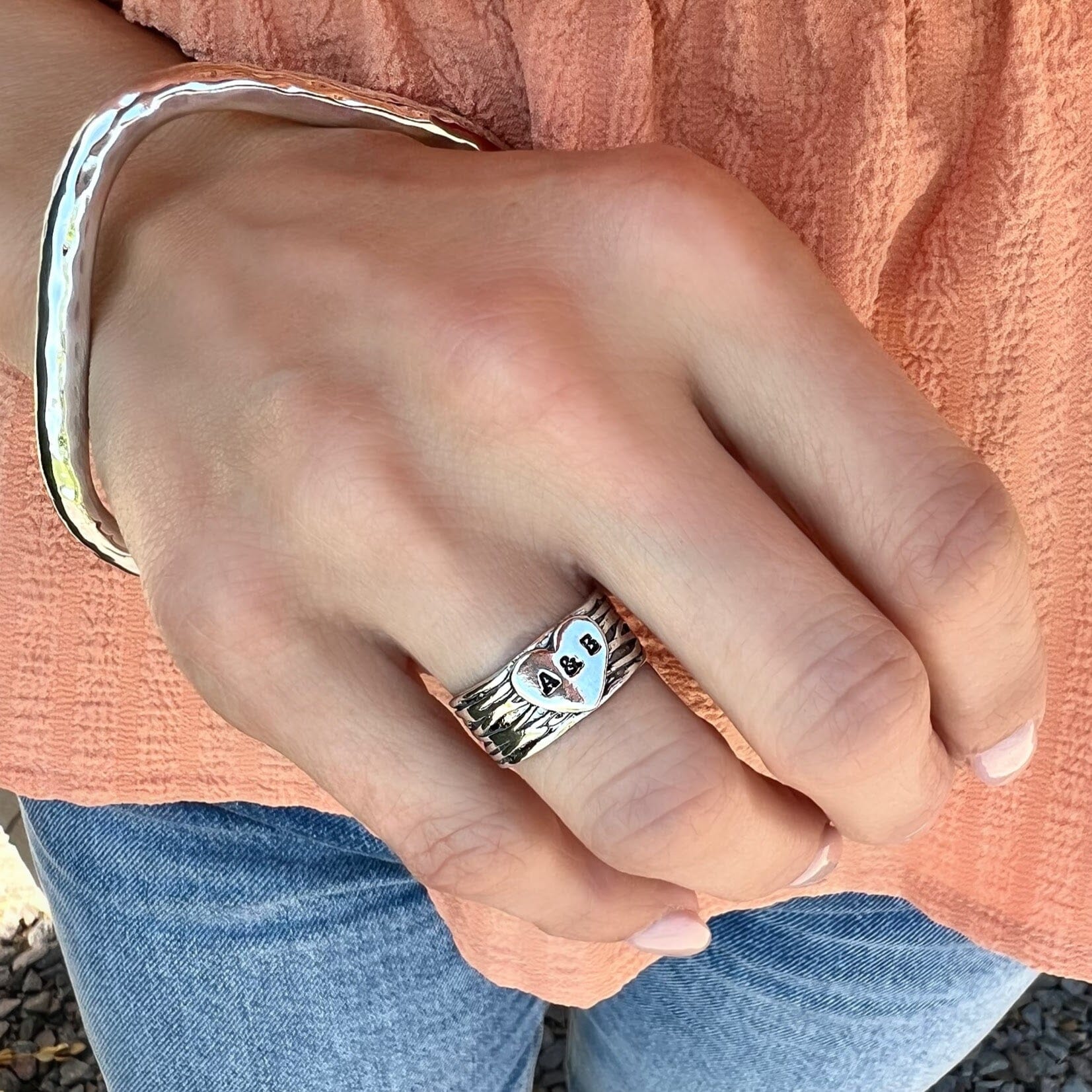 wide personalized ring with a silver heart center hand-stamped with two initials