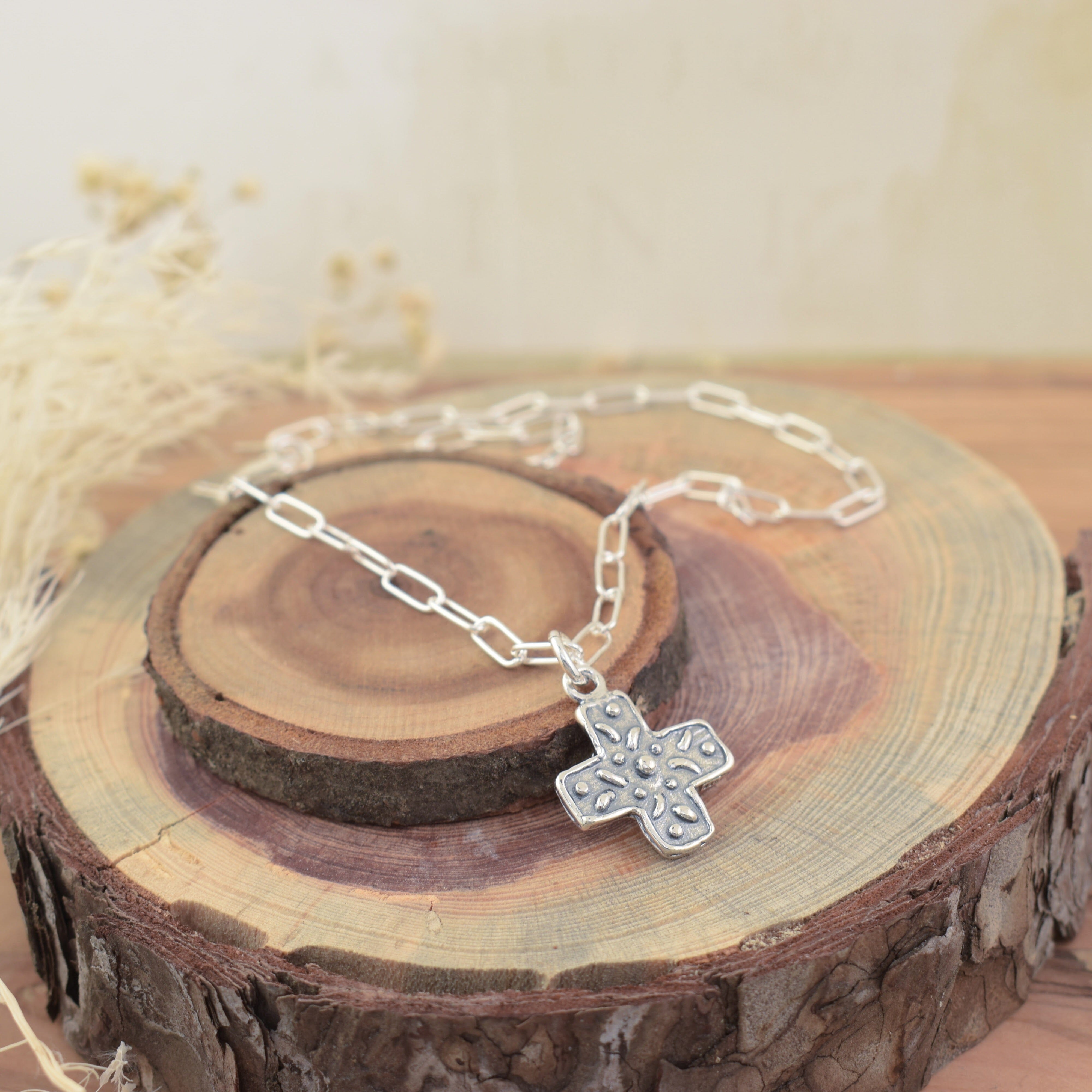 delicate paperclip chain featuring a silver oxidized cross pendant