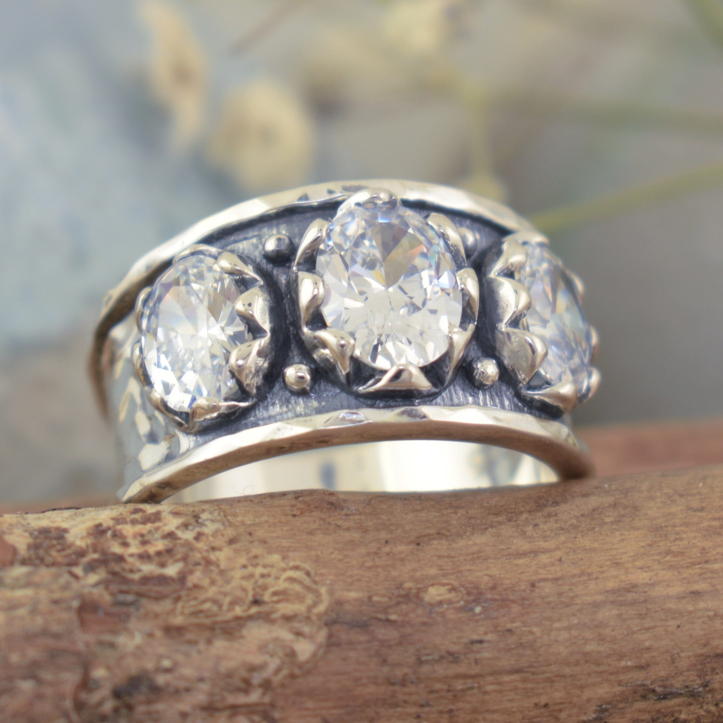 chunky silver ring featuring three oval prong set CZ stones with beaded details in between