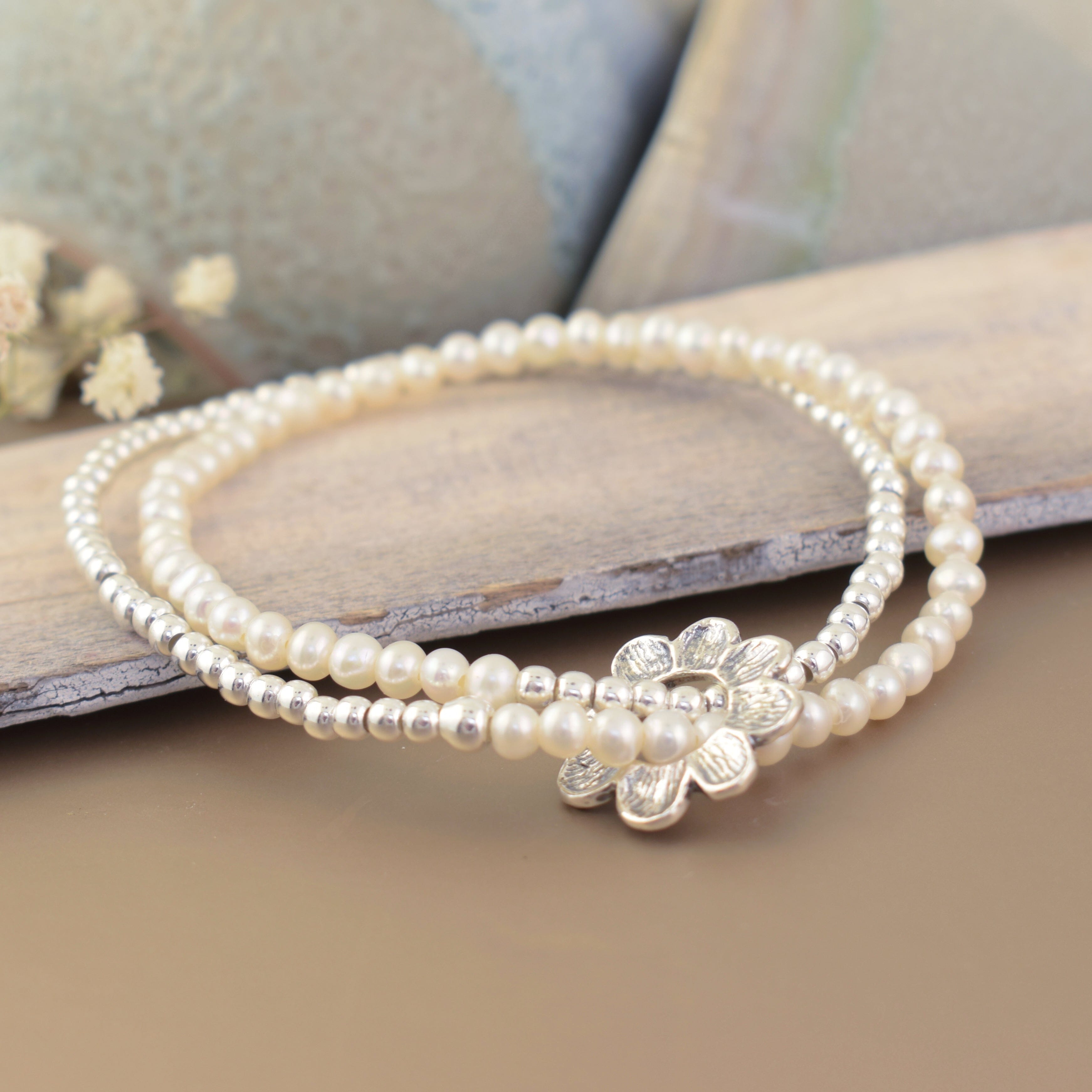 sterling silver bead and freshwater pearl stretch bracelet featuring a silver flower sliding pendant